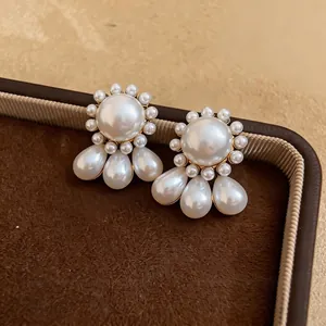Elegant round and teardrop pearl drop earrings with a vintage golden finish.