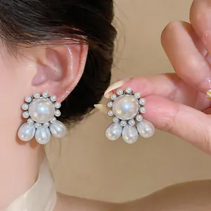 Macro view of elegant silver needle stud earrings with round and water-drop pearls