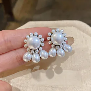 Detailed view of elegant round and water-drop pearl stud earrings with luxury gold finish