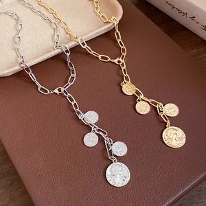 Close-up detail of gold and silver metal chain necklaces with multiple coin portrait pendants