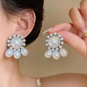 Close-up of elegant oversized white pearl drop earrings with silver needle studs for women