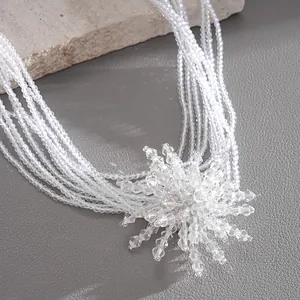 Close-up detail of multi-layered clear crystal flower necklace with intricate beadwork