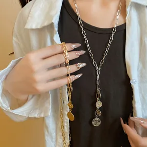 Detailed view of silver and gold metal chain necklaces with round coin pendants