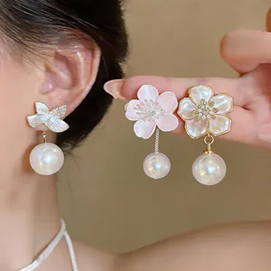 Detailed view of elegant cherry blossom pearl earrings with pink enamel and crystal accents