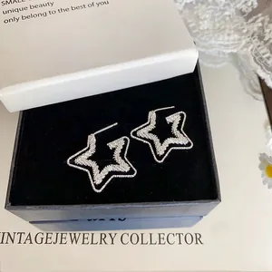 Dettaglio degli orecchini a stella a doppio strato in una scatola regalo elegante