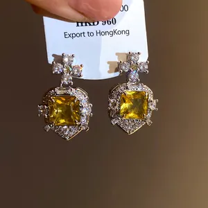 Detailed view of luxury vintage style square yellow zircon earrings with cross design