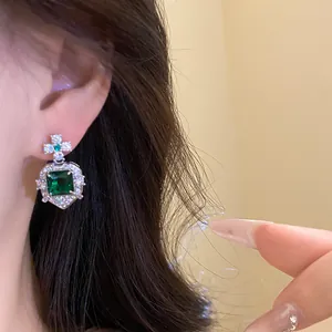 Macro view of vintage style square green zircon drop earring worn by an Asian model.