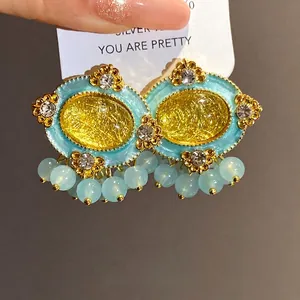 Vintage-style resin oval stud earrings with rhinestones and light blue bead dangles