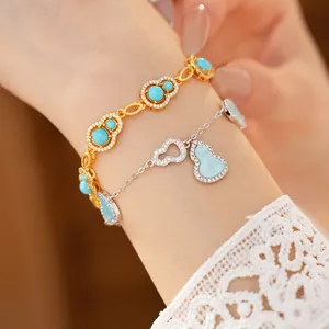 Close-up of elegant gold and silver hollow gourd bracelets with blue stones on a wrist.