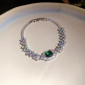 Close-up detail of a silver palace-style bracelet with a square green gemstone and zircons