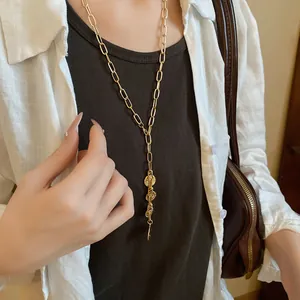 Chic gold chain necklace with layered portrait coin pendants on a fashion model