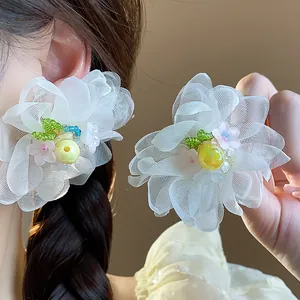 Close-up of elegant white chiffon flower earrings accented with delicate colorful beads