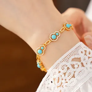 Close-up of gold gourd bracelet with turquoise blue stones and zircon pavé detail