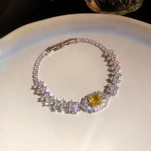 Elegant silver-toned bracelet featuring sparkling zircons and a central yellow square stone.