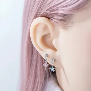 Pendientes de titanio para cartílago con estrellas rosa y azul en oreja de modelo