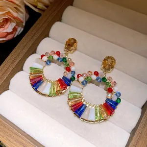 Exquisite colorful crystal hoop earrings displayed in a beige luxury jewelry box