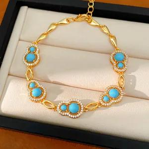 Detailed macro view of gold-plated bracelet with blue stones and hollow gourd charms