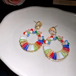 Close-up of vibrant multi-colored crystal hoop earrings with elegant silver needles
