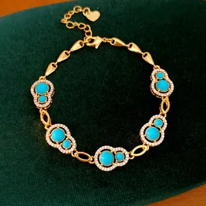 Detailed view of a gold-plated bracelet with turquoise gourd charms and white zircons
