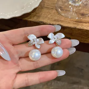Close-up of elegant cherry blossom pearl earrings with crystal accents and shell texture