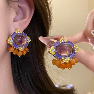 Detailed view of vintage resin oval stud earrings featuring rhinestones and orange beads