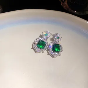 Macro view showing the fine zircon pavé setting on square emerald green drop earrings