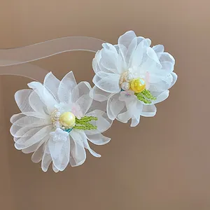 Close-up of elegant chiffon flower stud earrings with pearl and bead detail on silver needles