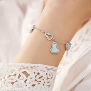 Detailed close-up of a delicate silver bracelet featuring light blue gourd charms and zircon.