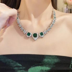 Detail of royal style silver-tone necklace with square emerald green stones