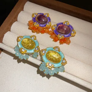 Detailed close-up of vintage court style oval resin earrings with rhinestones and beads.