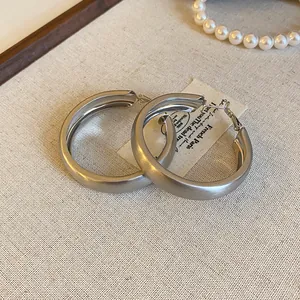 Macro view showing the elegant brushed matte texture of silver minimalist hoop earrings