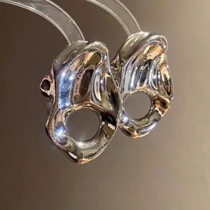 Pendientes de botón metálicos con diseño geométrico irregular y acabado plateado moderno