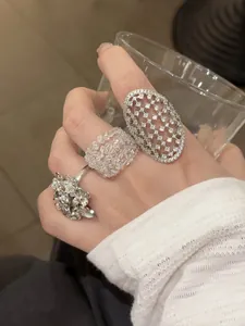 Detaillierte Ansicht mehrerer silberner Vintage-Nische-Ringe an einer Hand getragen