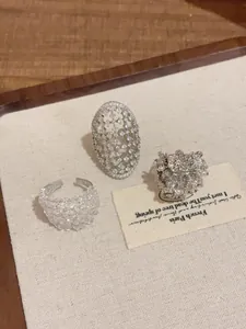 Nahaufnahme von drei einzigartigen silbernen Vintage-Ringen auf einer cremefarbenen Matte