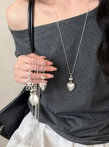 Vue détaillée de colliers en argent avec pendentifs cœur et fleur sur un mannequin