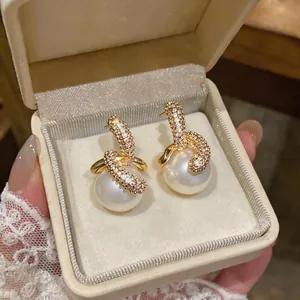Detailansicht von 18K vergoldeten Perlenohrringen mit eleganten Zirkoniasteinen