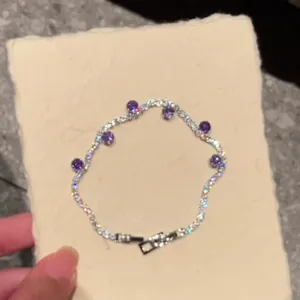 Detailed close-up of a sparkling zircon tennis bracelet with purple gemstones