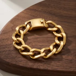 Vista detallada de una pulsera cubana de acero inoxidable dorado sobre madera