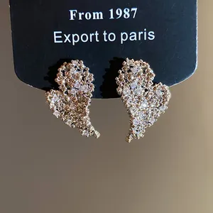Dettaglio degli orecchini a cuore placcati oro 18k con zirconi scintillanti di lusso