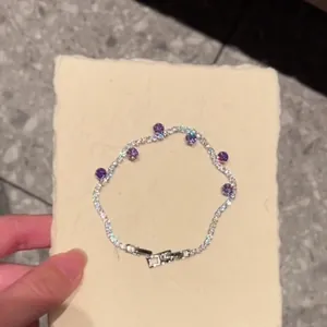 Close-up detail of a minimalist zircon bracelet featuring elegant purple stones and secure clasp.