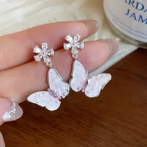 Detailed close-up of sparkling zirconia butterfly and flower drop earrings for women