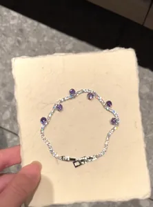 Detailed macro view of a sparkling zircon bracelet featuring six round purple gemstones