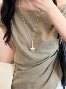Gros plan d'un collier pendentif étoile en argent de style coréen porté par un mannequin