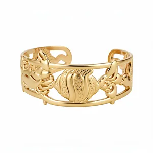 Gold hollow cuff bracelet with marine motifs like crab and fish in a retro style