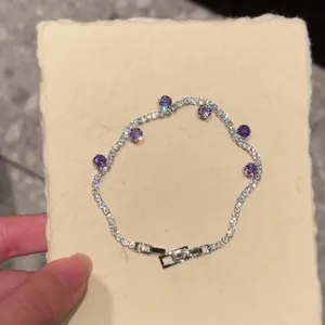 Close-up of elegant tennis bracelet with purple zircons and secure clasp
