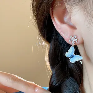 Detail view of exquisite butterfly stud earring featuring blue wings and zircon flowers