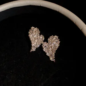 Primo piano di orecchini a cuore placcati oro 18 carati con zirconi brillanti in scatola.