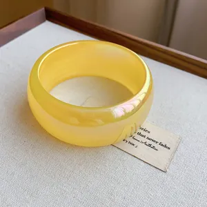Primer plano de brazalete amarillo translúcido iridiscente con efecto de brillo