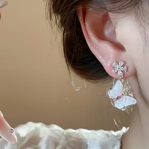 Close-up of zircon butterfly flower stud earrings with elegant silver finish.
