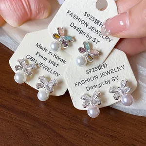 Elegant close-up view of floral zirconia and pearl earrings with S925 silver needles